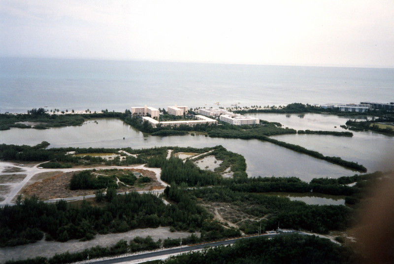 Aerial view of ponds with buildings and roads around them.