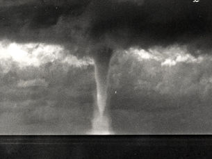 A waterspout descending from clouds to the water.