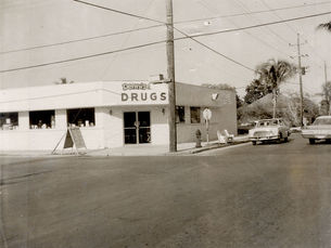 a building with a sign over the door that reads Dennis drugs