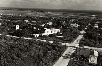 Aerial view of a mostly undeveloped area with a burned out building in the center
