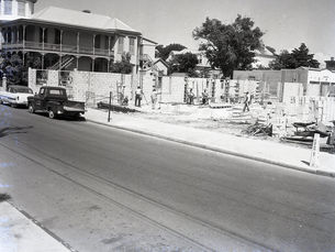 a street with a building under construction on one parcel