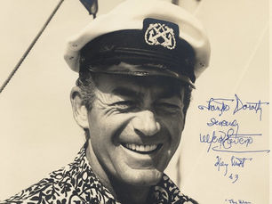 autographed photo of a man wearing a captain's cap.