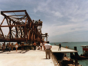 People standing in front of a truss section on a bridge