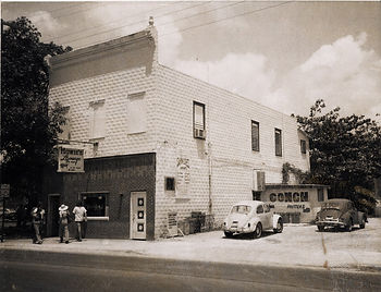 People in front of a building with signs that read Howie's Lounge and Conch Fritters.