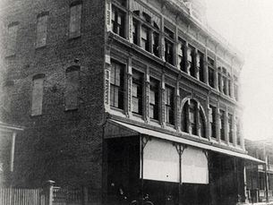 A three-story brick building with an awning over the sidewalk in front