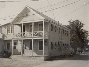 A two story house with porches on both levels
