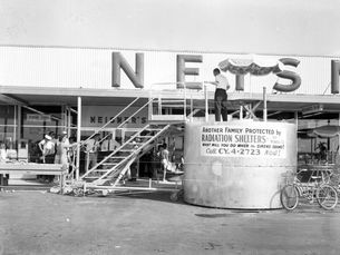 A round concrete structure in front of a storefront.