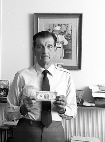A man holding a $1 bill.