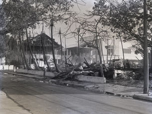 building wreckage on a street with other buildings in the background.