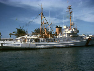 A docked Coast Guard vessel with 85 written on the hull