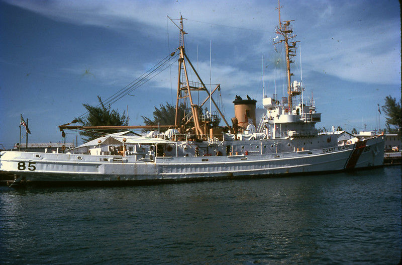 A Coast Guard vessel at a dock with the number 85 written on the hull.