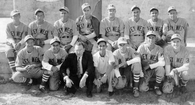 Two rows of men, most of them wearing baseball informs with Key West written on the front.