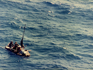 Aerial view of people on a makeshift raft in the waterbanner that reads Americansim Week Junior Chamber of Commerce