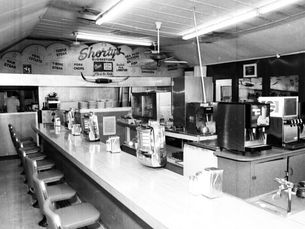 Interior of a diner with a countertop and Shorty's written on the back wall.