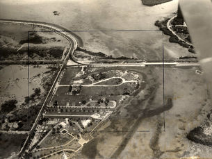 Aerial view of the end of an island with a bridge connecting it to another island.