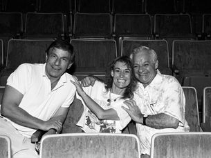 Three people sitting in theater seats.