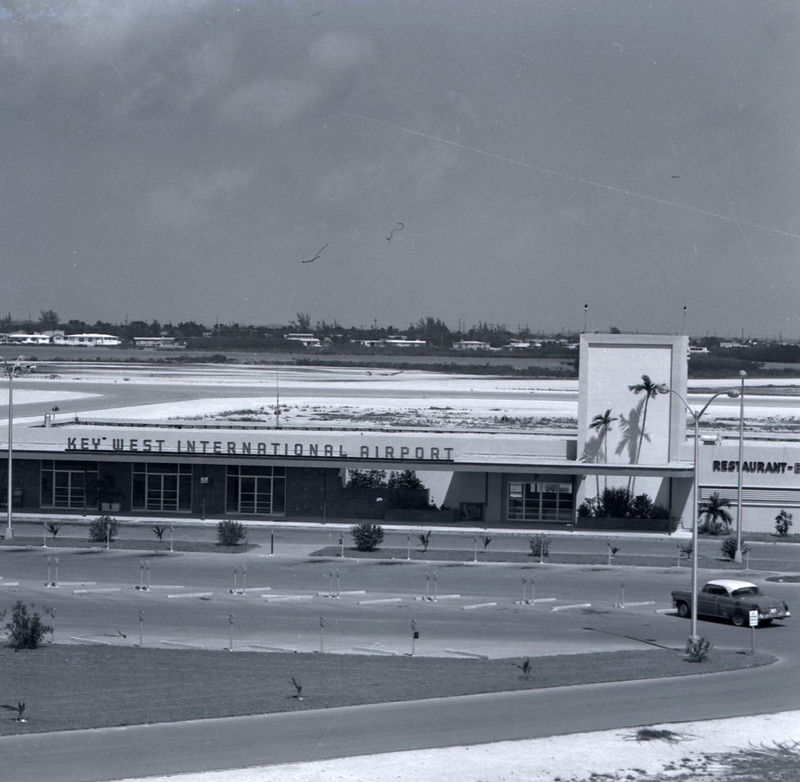 A one story building with a tower at one end and a sign that reads Key West International Airport.