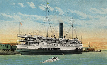 Postcard of a steamship at a dock with a small dinghy approaching it.