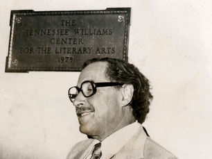 A man in front of a plaque reading The Tennessee Williams Center for the Literary Arts, 1975.