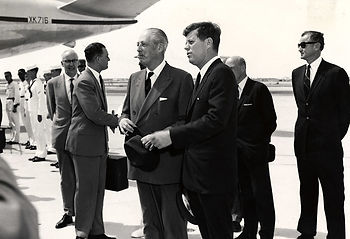 People standing near the tail of an airplane.