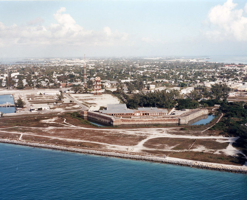 Aerial view of a brick fort with a moat near a shoreline